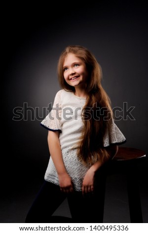 Studio portrait of a girl 6-7 years old .Cute little girl posing in studio on dark background.