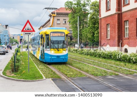 Colourful tram runs on tramway track over green grass area in Kosice (SLOVAKIA), Translation = “Train station square”  