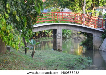 A small red curved bridge is good for tourists taking pictures in the Bulaksumur tourist park.