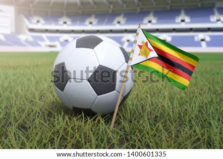 Zimbabwe flag in stadium field with soccer football