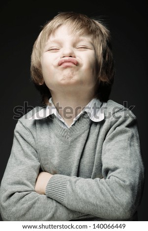 Image of funny young boy over gray background