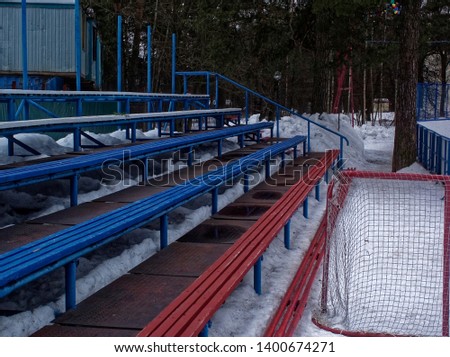 wooden benches near hockey ground in winter, Moscow
