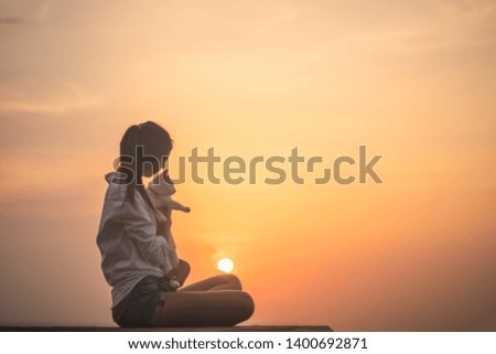 Silhouette of free woman enjoying freedom feeling happy with her cat at sunset