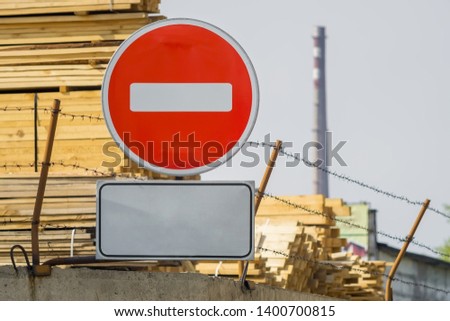 sign, symbol, warning about the prohibition of entry to the territory of the industrial zone with building materials, lumber, placed on the fence with barbed wire