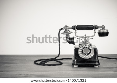 Vintage old telephone on wood table black and white photo