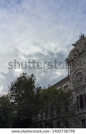Buildings decorated with stucco and statues against the blue sky and white clouds. On the streets in Catalonia, public places.