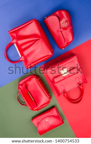 Set of different types of red fashion women handbags on red green and blue background. Fashion poster concept. Pile of fashion women background. Top View. Flat Lay. Mock up. Card design.