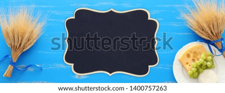top view photo of dairy products over blue wooden background. Symbols of jewish holiday - Shavuot