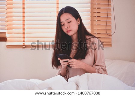 Women hording mobile smartphone  on bedroom