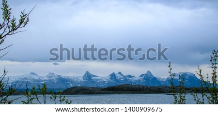 The Seven Sisters mountain range (Seven Sisters) with wonderful beautiful clouds over them. The picture was taken from Herøy, Nordland, Helgeland, Norway.