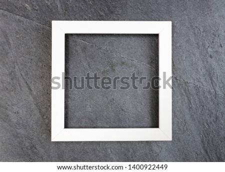 White wooden square frame on black slate background