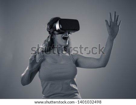 Amazed attractive woman using VR headset glasses touching and interacting with virtual reality world. Feeling excited exploring and having fun in 360 VR simulation. Innovation and new technology.