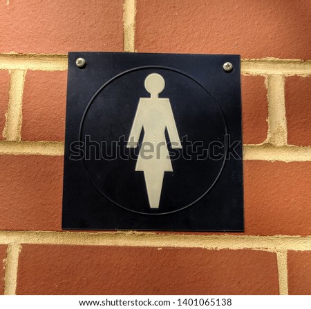 Toilet for females sign on brick wall