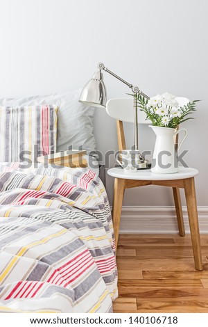 Bright and fresh bedroom decorated with a bouquet of flowers. Royalty-Free Stock Photo #140106718