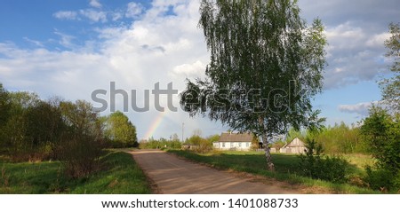 A village, a birch tree by the road, a rainbow in the background. Design wallpaper, desktop wallpaper, postcard, picture for a puzzle.
