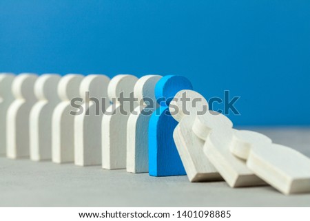 Domino effect in business. One businessman falls and brings down other figures of employees. Prevent the destruction of the system. Crisis manager stops falling dominoes