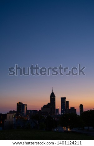 City skyline at dusk with blue sky and faint glow of orange