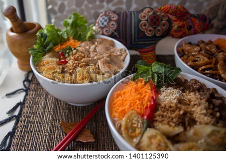 Vietnamese food: Bo Bun Vegetarian, Bo Bun Beef, Bo Buan Chicken, served with asian decoration and Vietnamese Buffalo symbol.