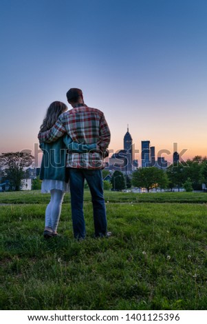 Couple watching the sunset with city skyline in the background