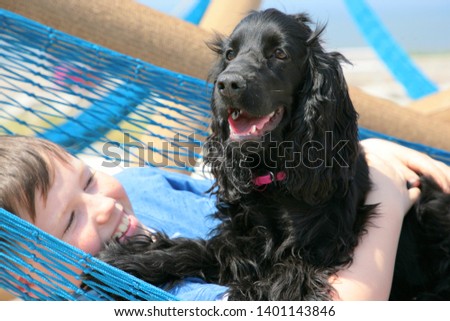 boy playing with a dog in a hammock
