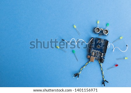 Back to school concept. A metal robot and an electronic board that can be programmed. Robotics and electronics. DIY robotics. STEM and STEAM education for kids. Free space for text. Royalty-Free Stock Photo #1401156971