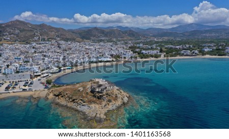 Aerial drone panoramic photo of famous turquoise sea sandy beach of Saint George next to chora main town of Naxos island with beautiful uphill castle, Cyclades, Greece