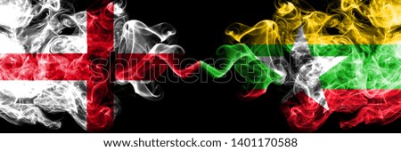 English vs Myanmar smoky mystic flags placed side by side. Thick colored silky smokes flag of England and Myanmar.