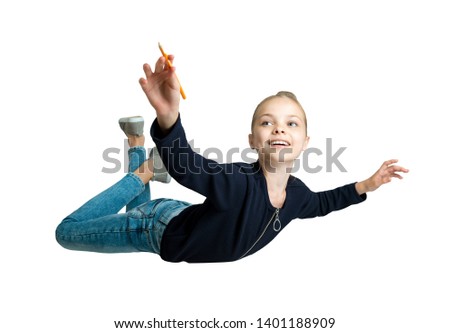 Happy cute child girl show point in the air by pencil. Flying kid with facial expression isolated on white.