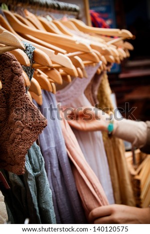 Recession bargains: rack of second-hand dresses for sale at market. Portrait orientation. Royalty-Free Stock Photo #140120575