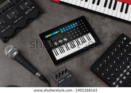Piano synthesizer app on tablet and musical instrument concept