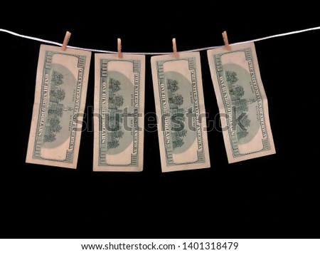 Banknotes of one hundred dollars hang on a rope with clothespins. The concept of dirty money. The dollar is falling. Money hang on a black background. - Image