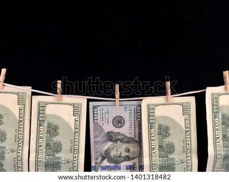 Banknotes of one hundred dollars hang on a rope with clothespins. The concept of dirty money. The dollar is falling. Money hang on a black background. - Image