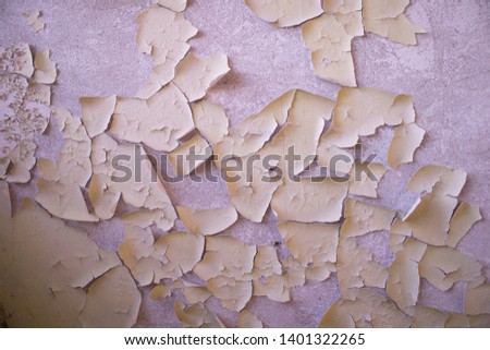 Wall fragment with scratches and cracks. Textured weathered yellow color handmade surface for background.