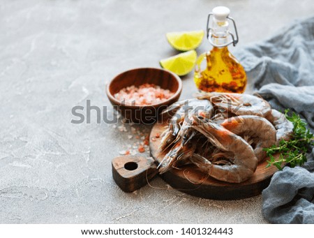 Fresh raw  prawns and spices on  grey concrete background