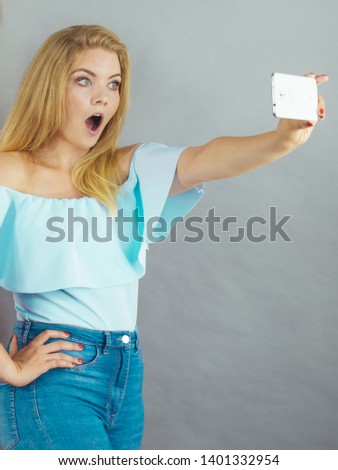 Fashionable woman taking selfie self picture using smartphone having fun.