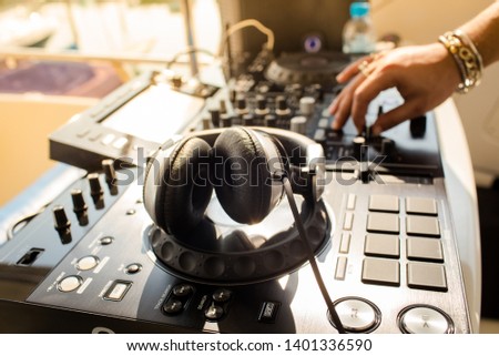Close up of DJ hands mixing music on a table. DJ in a night club