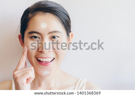 Portrait of Asian woman marking and applying cream concealer on her facial skin. Concealer is a type of cosmetic that is used to mask dark circles, age spots, large pores etc.