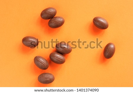 Chocolate eggs on the orange background
