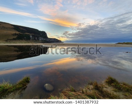 Reflection in fresh water at quick dawn shows amazing colors. Shores of New Zealand are stunning and filled with beauty. Pictures taken in South Island, Catlins area, summer 2019