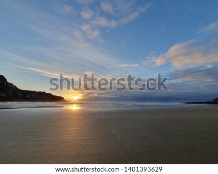 Sun rising above vast beach in South Island of New Zealand. Catlins area is well known for its beautiful beaches and coastlines. Picture taken in summer 2019, campsite by the ocean. 