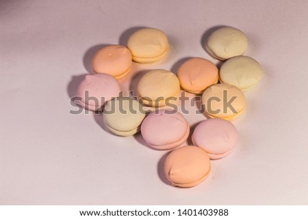 Almond cookies in a gift box and marshmallows. Multicolored meringues close-up top view. Sweet pasta and flowers. Selective focus. Macaroons are a dessert loved by millions