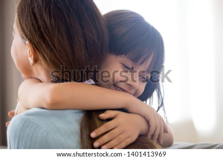 Close up of cute little girl hug young mom or nanny showing love and care, happy preschooler child embrace mother thank or ask forgiveness, smiling parent and small daughter kid cuddle reconcile Royalty-Free Stock Photo #1401413969