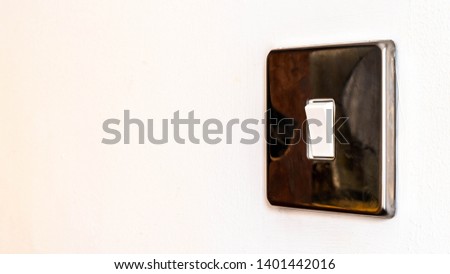 Close up of light switch turning on or off on . Copy space. Close up hand turning on or off on white light switch with white background. Copy space.
