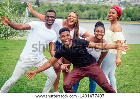 group of five smiling african-american men and women walking outside cloudy weather near the lake,exchange students in Russia Royalty-Free Stock Photo #1401477407
