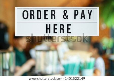 A business text ‘Order and Pay here’on blurred of cafe or restaurant entrance background. Industry food, Cafe and restaurant idea concept. Image with clipping path.
