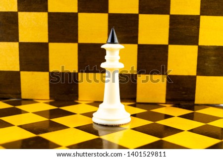 white chess king stands against the background of the chessboard