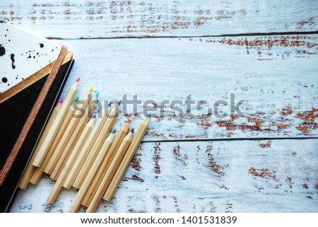 Close up of notebook and pencil on wooden table.