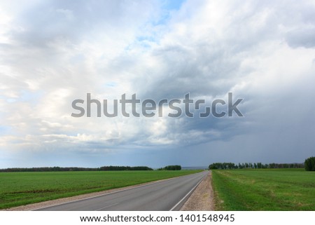 The road in the Russian village with a cloudy sky before a thunderstorm.