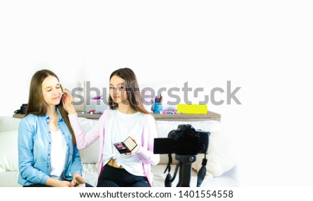 Two teen girls blogger presents beauty products and transmitting live video to social networks. Focus on the influencer of teenage blogger girls. Beauty blogger and vlog concept.