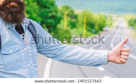 Thumb up sign not work in many parts of the world. Hand thumb up gesture try stop car road background. Thumb or hand gesture hitchhiking. Make sure you know right gestures used locally to stop car.